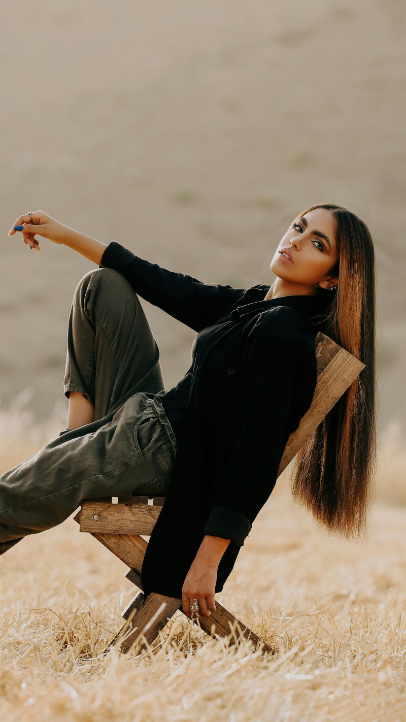 Woman in black clothes sitting on a chair 4K Mobile Wallpaper