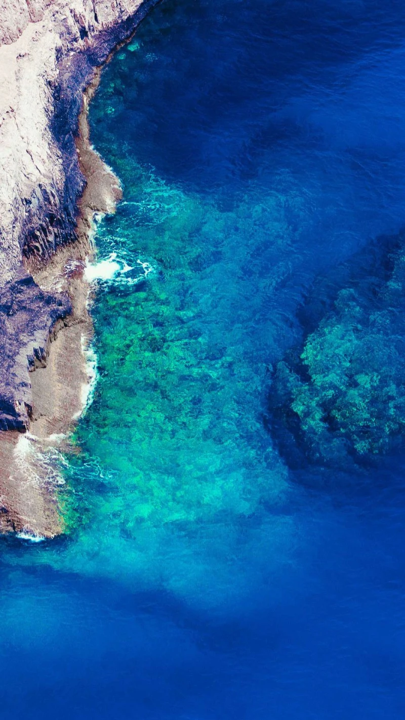 Aerial View of Turquoise Ocean and Rocky Coastline 4K Mobile Wallpaper