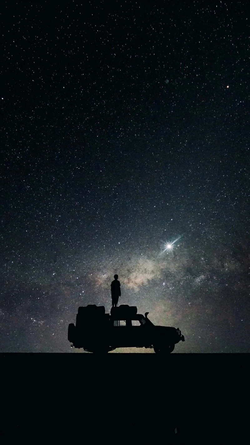 Silhouette of a Car and Person Under the Milky Way 4K Mobile Wallpaper