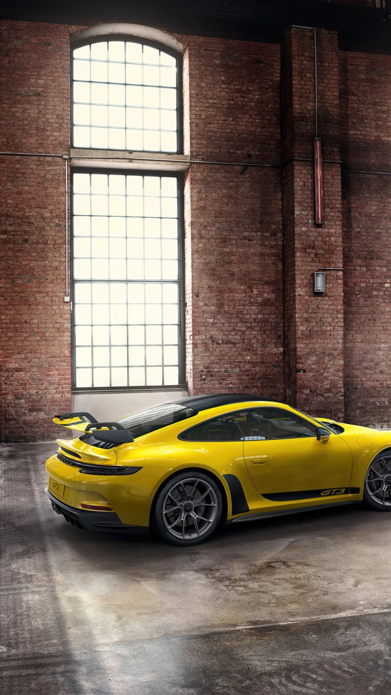 Yellow Porsche 911 GT3 in Industrial Setting 4K Mobile Wallpaper