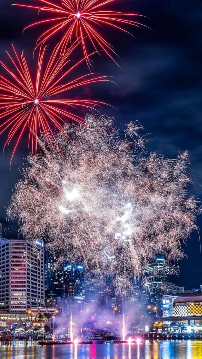 Vibrant Fireworks over City Skyline 4K Mobile Wallpaper