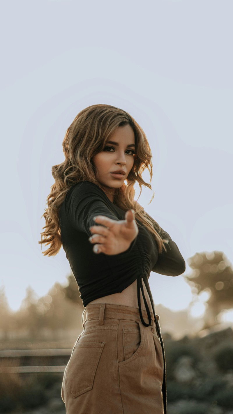 Mysterious Girl Gestures Outdoors 4K Mobile Wallpaper